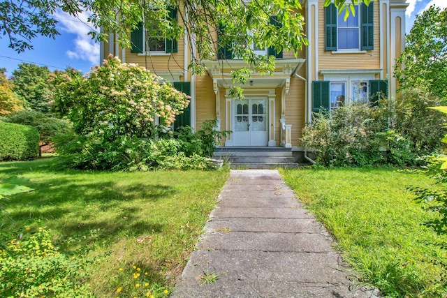 view of exterior entry featuring a yard