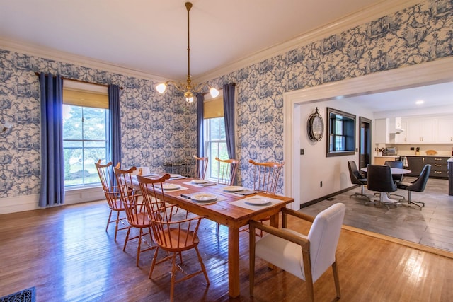 dining area featuring wood-type flooring, visible vents, and wallpapered walls