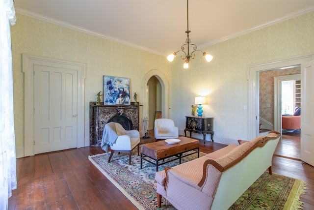 living area with arched walkways, dark wood-style floors, ornamental molding, a chandelier, and a high end fireplace