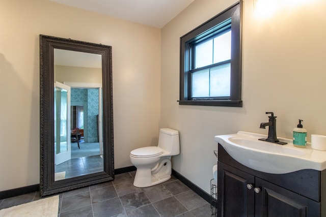 bathroom featuring baseboards, vanity, and toilet