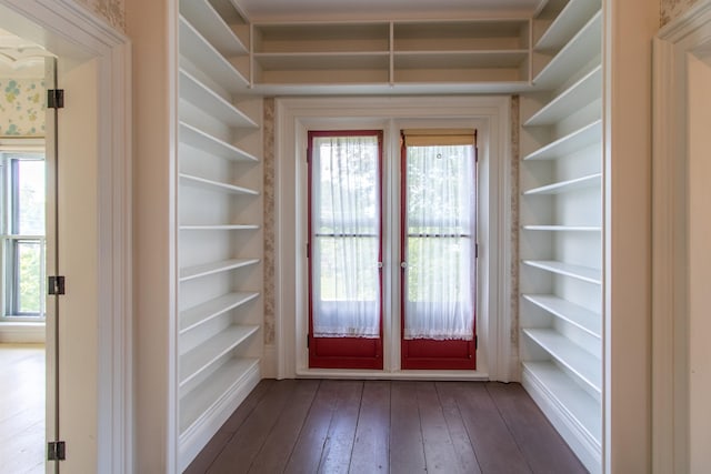 doorway to outside with dark wood finished floors and built in features