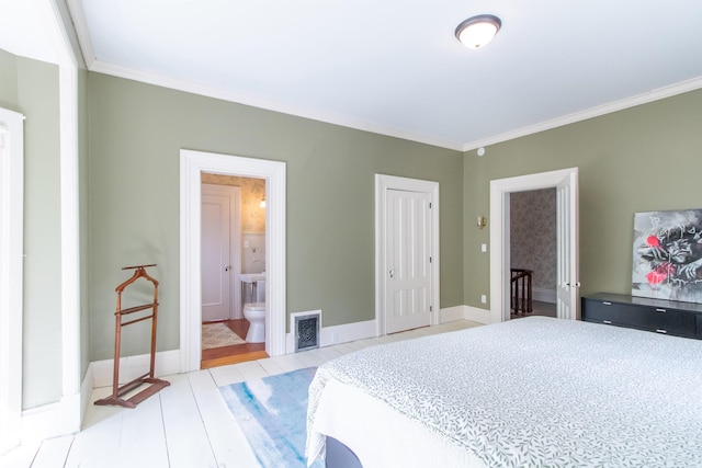 bedroom featuring baseboards, visible vents, connected bathroom, wood finished floors, and crown molding