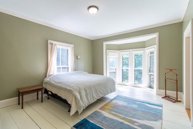 bedroom with baseboards, light wood-style flooring, and crown molding