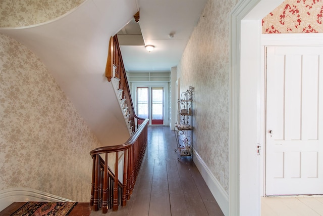 corridor featuring wallpapered walls, stairway, and hardwood / wood-style flooring