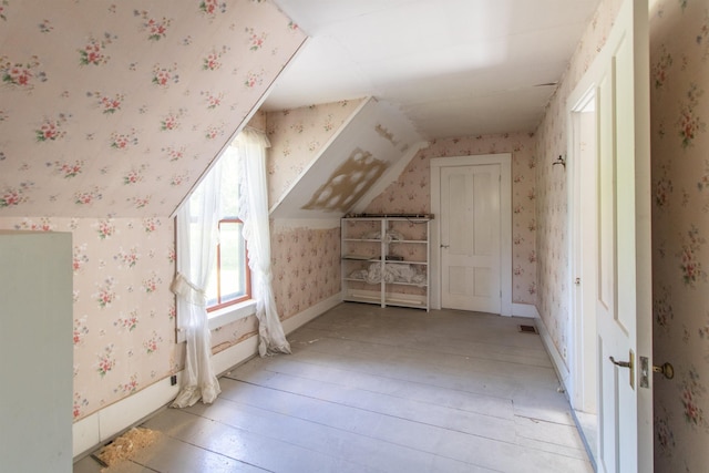 additional living space featuring light wood-style floors, baseboards, and wallpapered walls