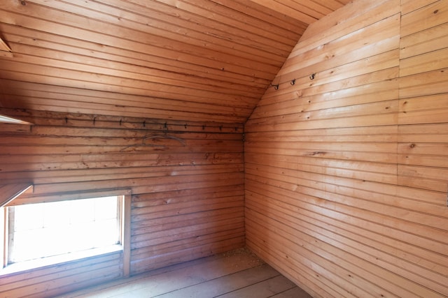 unfurnished room with vaulted ceiling, a sauna, wood finished floors, and wood ceiling