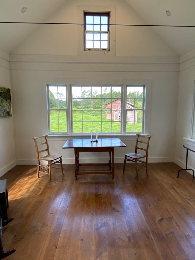 unfurnished dining area with vaulted ceiling and dark hardwood / wood-style floors