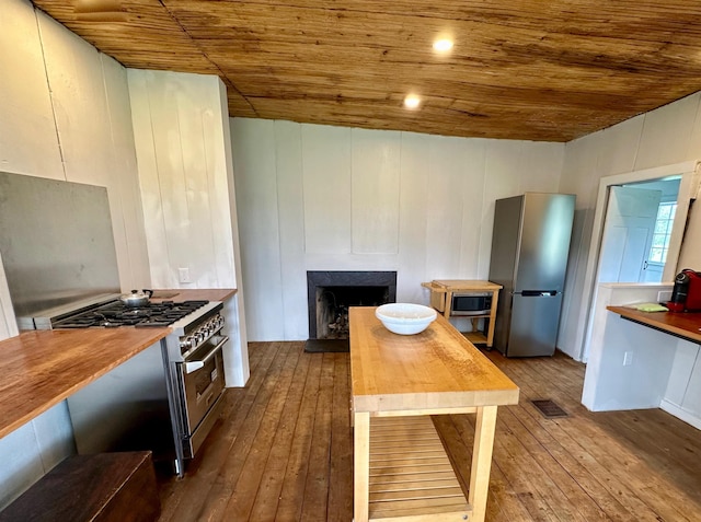 kitchen featuring appliances with stainless steel finishes, white cabinets, wooden ceiling, and wood-type flooring