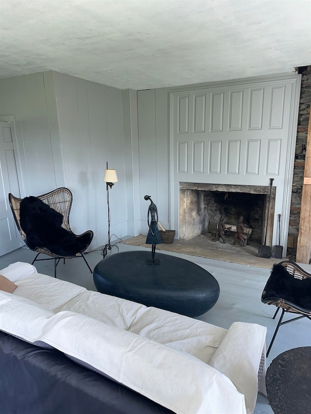 living room with a stone fireplace and wood-type flooring