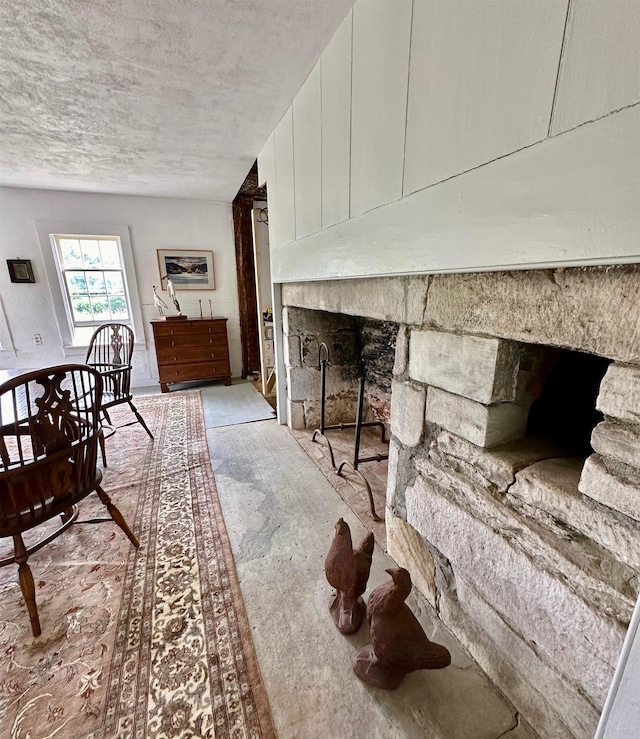 interior space with a stone fireplace and a textured ceiling