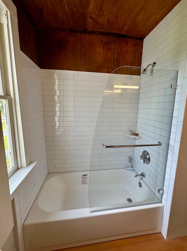 bathroom featuring hardwood / wood-style floors, tiled shower / bath combo, and wooden ceiling