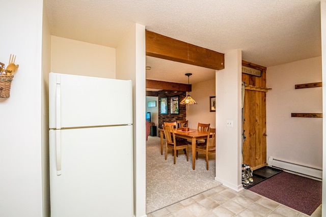 kitchen featuring pendant lighting, a baseboard radiator, white fridge, and a textured ceiling