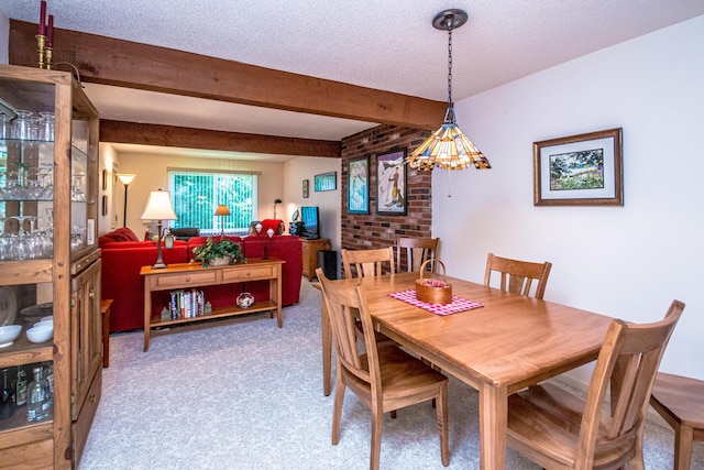 dining area featuring beam ceiling and a textured ceiling