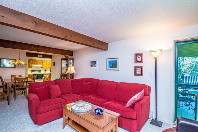 living room featuring beam ceiling, carpet floors, and a textured ceiling