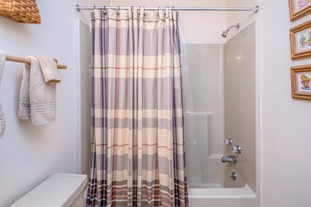 bathroom with toilet and shower / bath combination with curtain