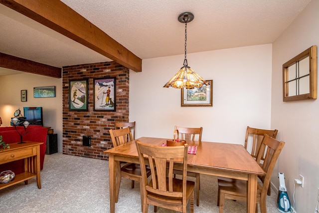 carpeted dining area with beam ceiling and a textured ceiling