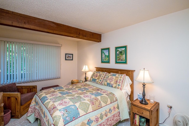 bedroom with a textured ceiling, carpet flooring, and beam ceiling