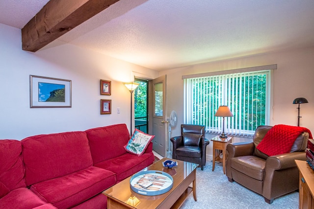 carpeted living room with a textured ceiling and beamed ceiling