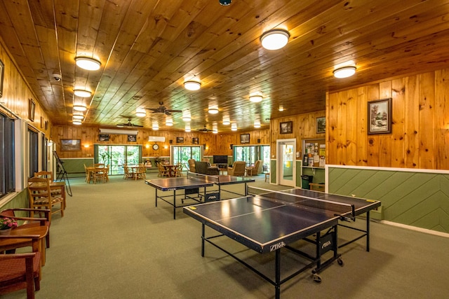 playroom with ceiling fan, wooden ceiling, wooden walls, and carpet flooring