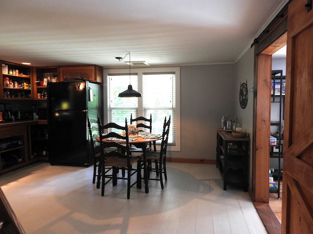 dining area featuring wood-type flooring and crown molding