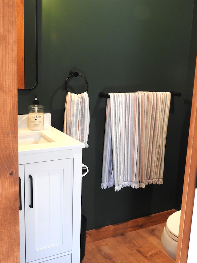 bathroom with vanity, toilet, and wood-type flooring