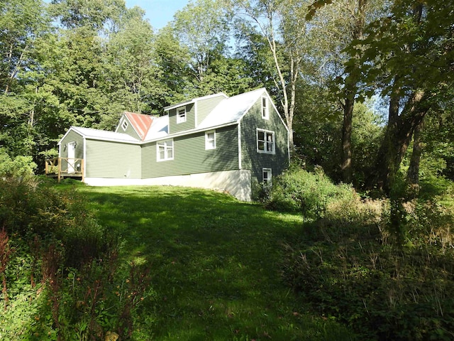 view of side of home with a yard