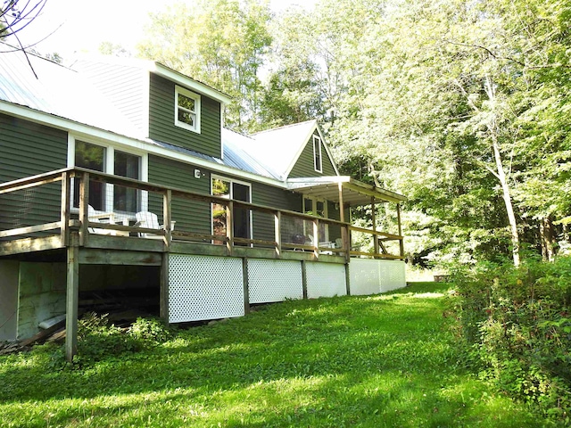 rear view of property with a yard and a deck