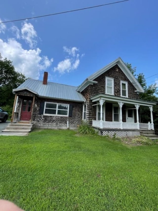 view of front facade featuring covered porch and a front yard