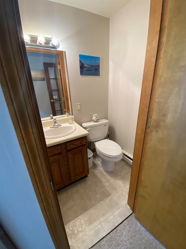 bathroom with toilet, vanity, and baseboard heating