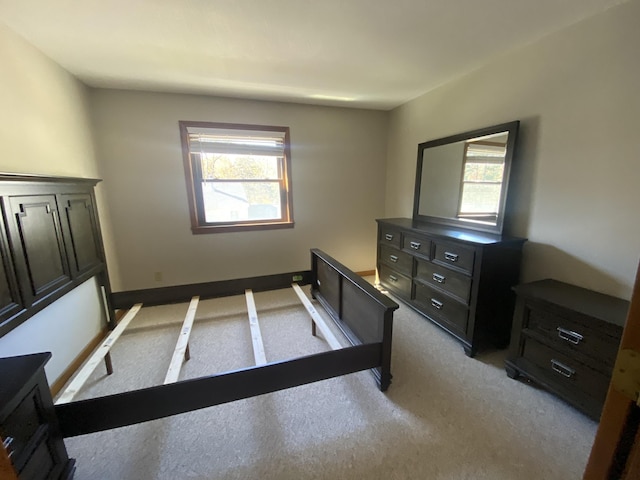 bedroom featuring light colored carpet and baseboards