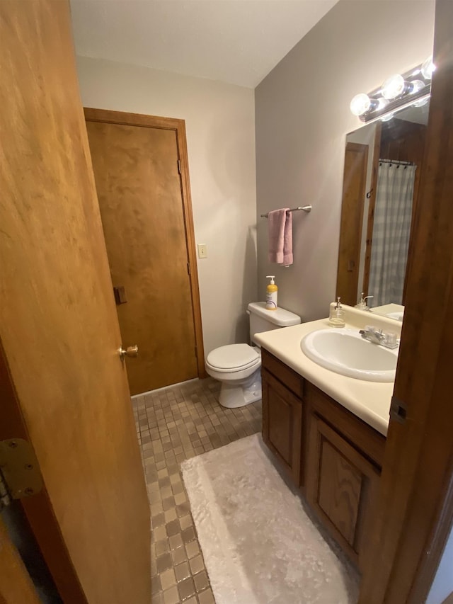 full bathroom with curtained shower, vanity, and toilet