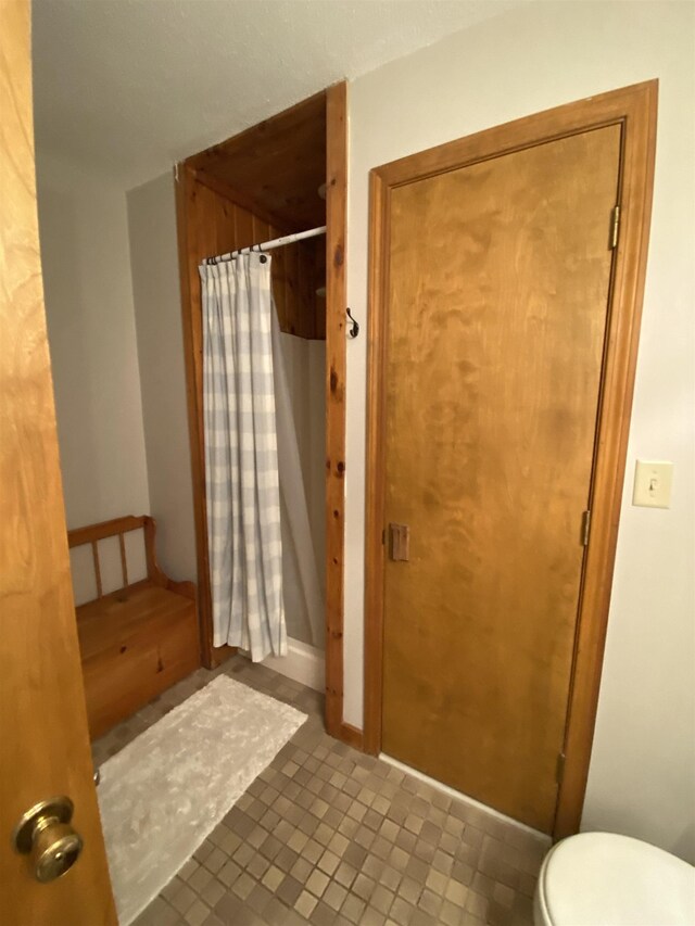 bathroom with toilet, vanity, and tile patterned flooring