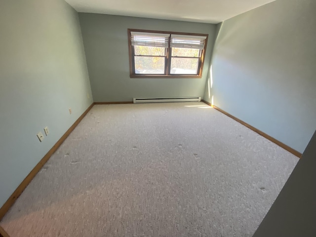 spare room with carpet, a baseboard radiator, and baseboards