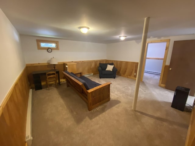 basement featuring wooden walls, a baseboard heating unit, light carpet, baseboard heating, and wainscoting