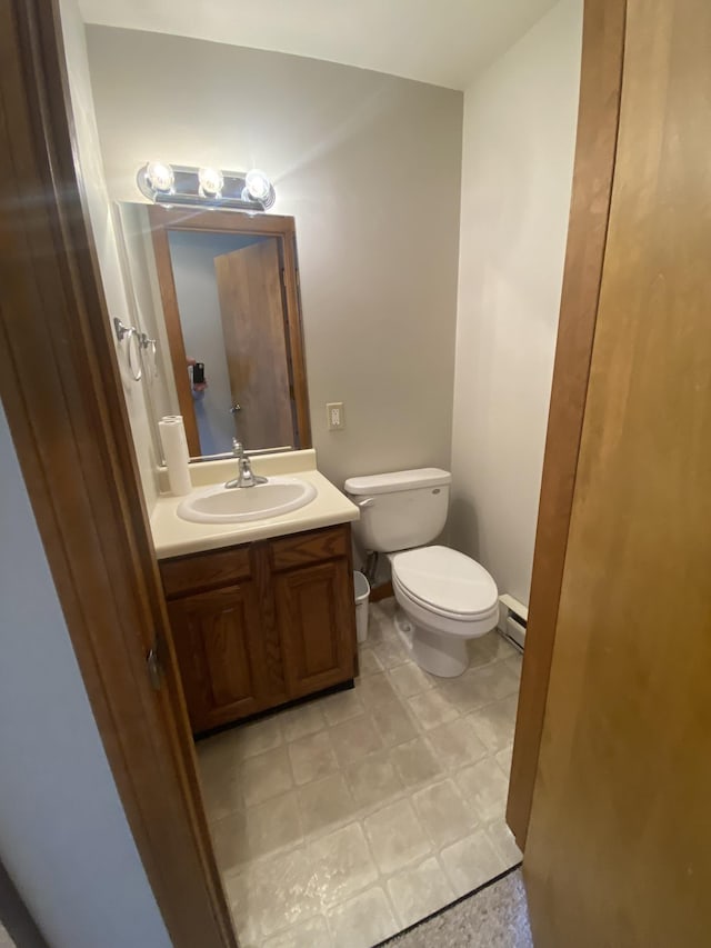 bathroom featuring toilet, baseboards, baseboard heating, and vanity