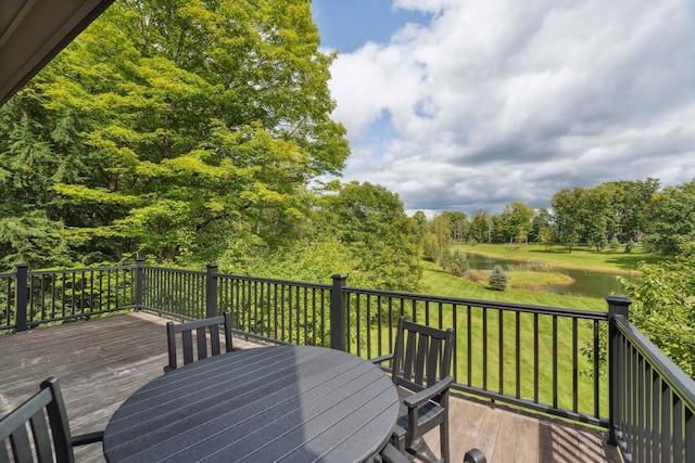 wooden deck with a lawn and a water view