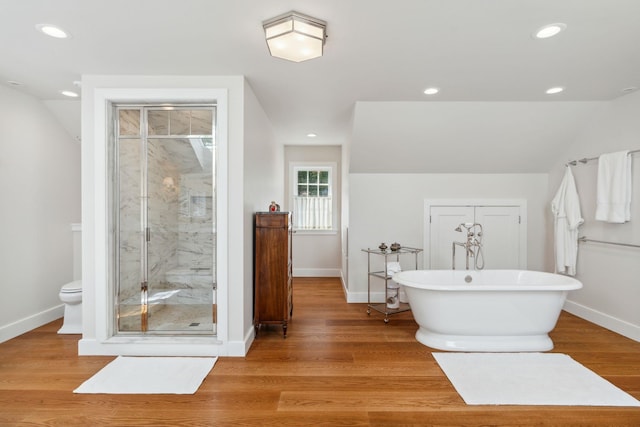 bathroom featuring plus walk in shower, hardwood / wood-style flooring, and toilet