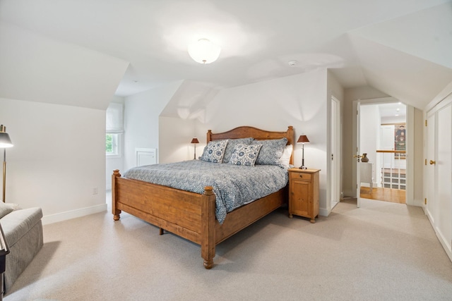 carpeted bedroom with lofted ceiling