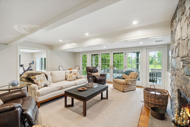 living room with french doors and a stone fireplace