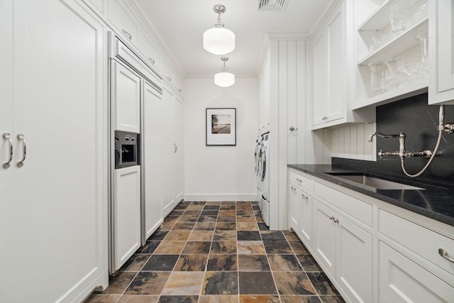 kitchen featuring white cabinetry, sink, backsplash, crown molding, and decorative light fixtures