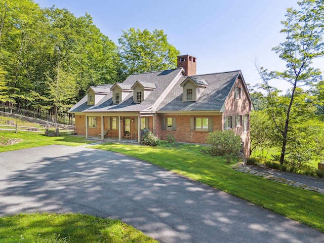 cape cod house featuring a front yard