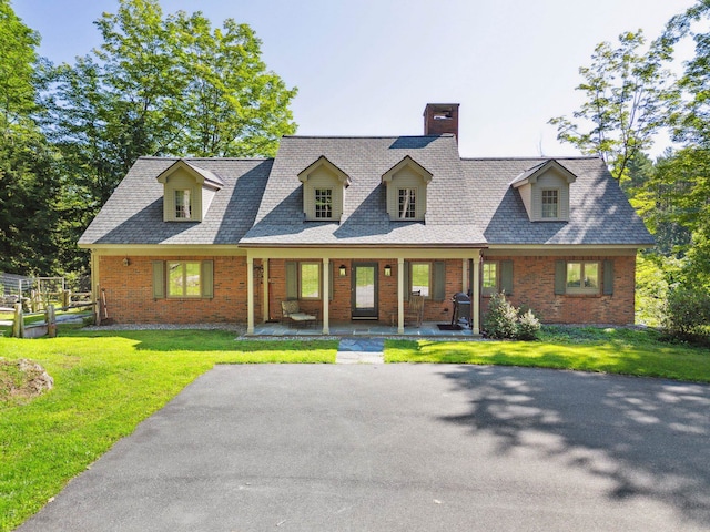 cape cod home featuring a porch and a front yard