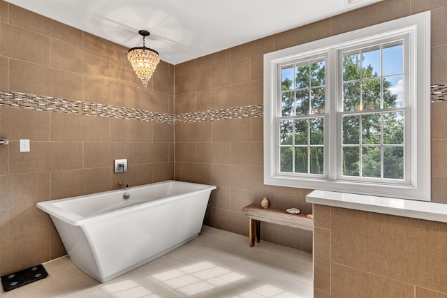 bathroom featuring tile patterned flooring, tile walls, and a freestanding tub