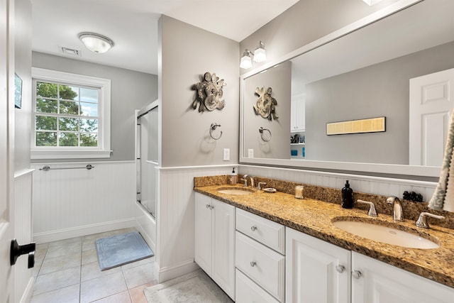 full bathroom featuring a wainscoted wall, tile patterned floors, visible vents, and a sink