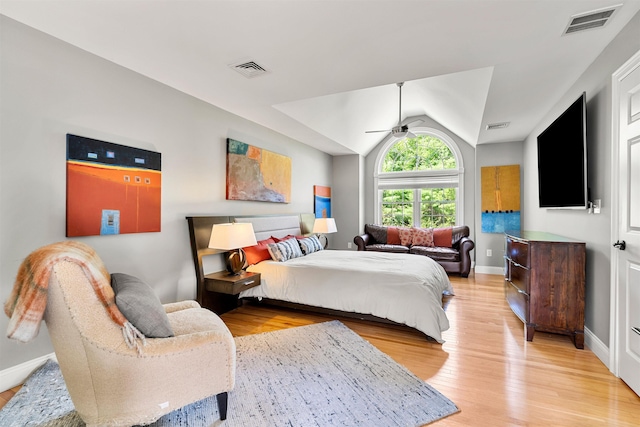 bedroom with a ceiling fan, lofted ceiling, light wood-style floors, and visible vents