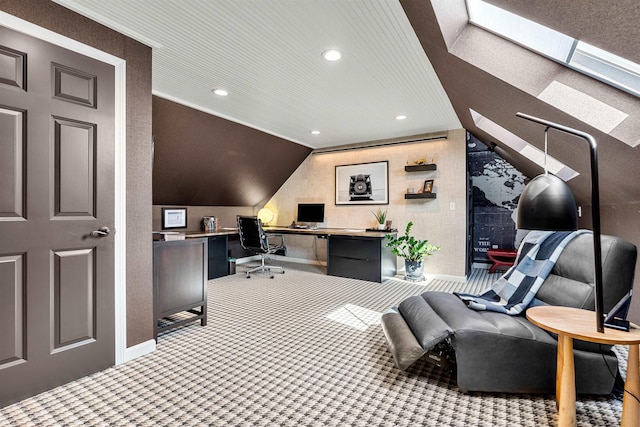 carpeted office space featuring vaulted ceiling with skylight, recessed lighting, baseboards, and built in study area