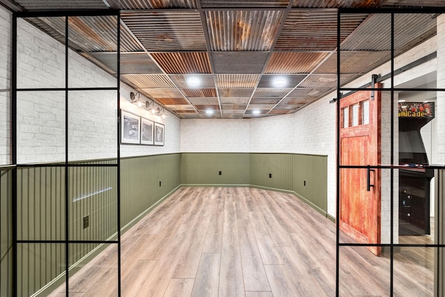 interior space with brick wall and wood finished floors