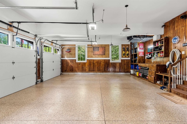 garage featuring a garage door opener and wood walls