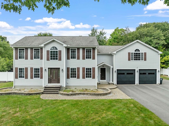 colonial home featuring a front yard and a garage