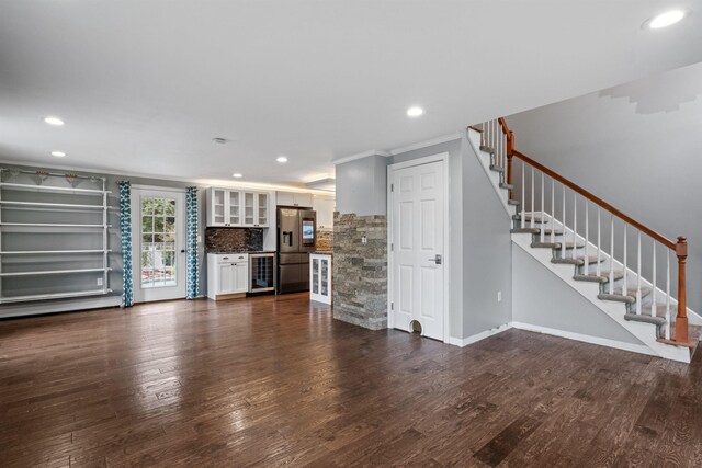 unfurnished living room featuring dark wood-type flooring, wine cooler, and ornamental molding